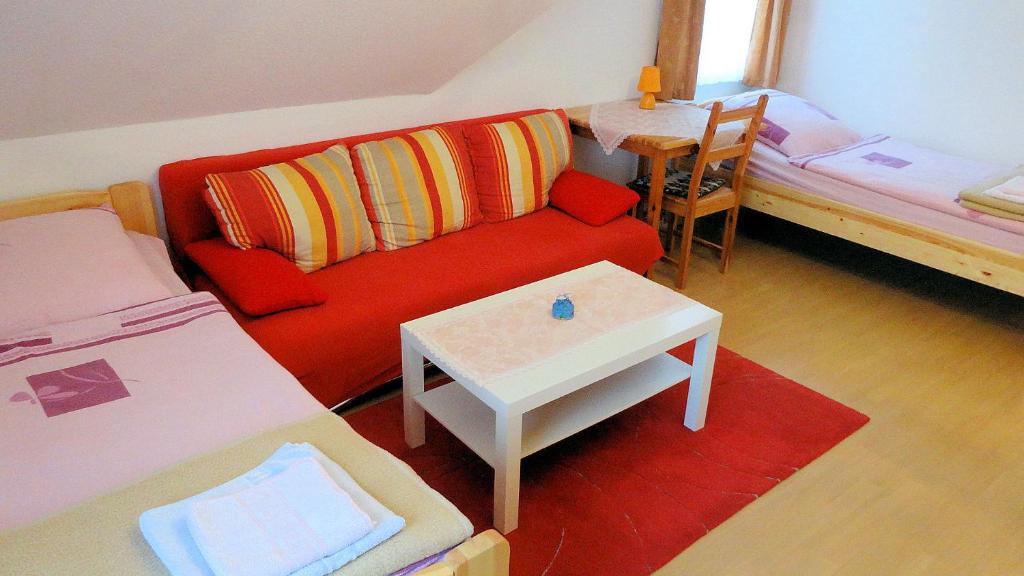 salon z czerwoną kanapą i stołem w obiekcie Charmantes Apartment in Mittelfeld w Hanowerze