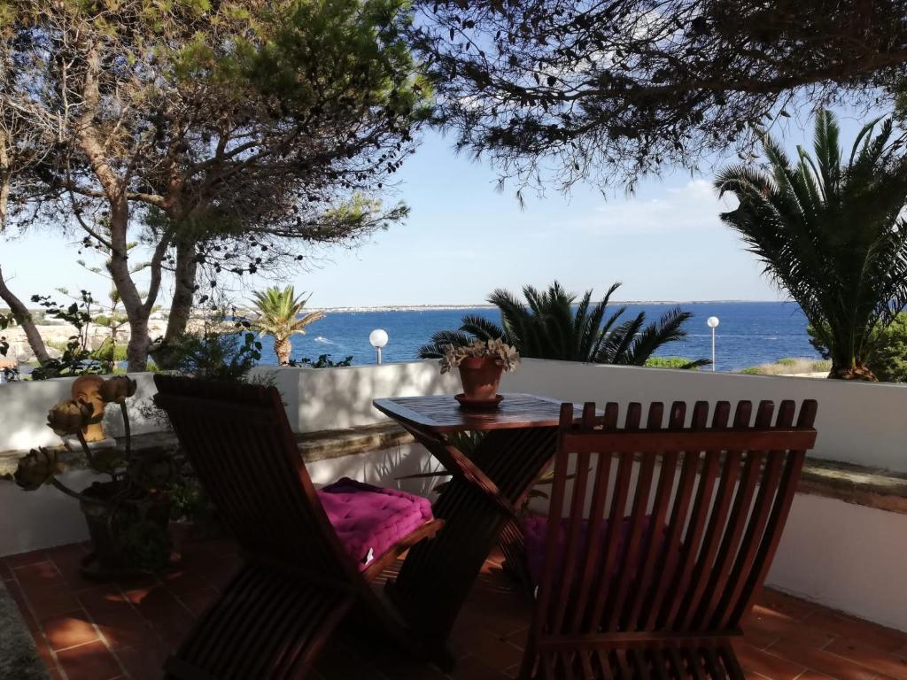 a table and chairs on a patio with a view of the ocean at villa Getty in Cala en Forcat