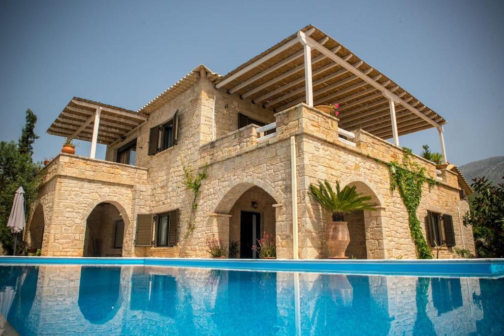 dom z basenem przed nim w obiekcie Magnificent, Authentic Private Villa and the Guest house w mieście Kardamyli