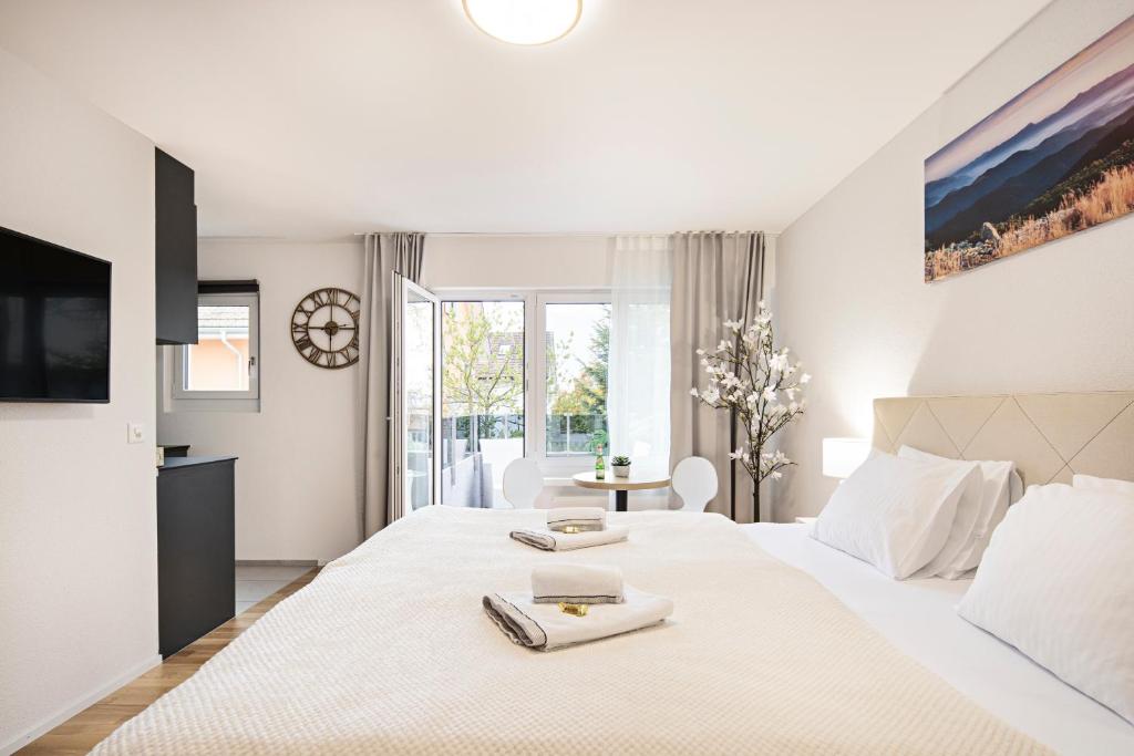 a white bedroom with a bed with two towels on it at EH Apartments Mars in St. Gallen