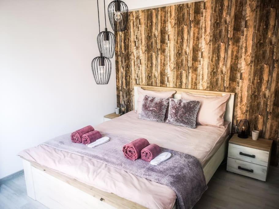 um quarto com uma cama com almofadas cor-de-rosa em Apartament Feels like home Secluded Terrace em Iaşi