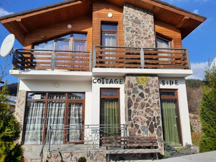 une maison avec un grand balcon au-dessus dans l'établissement Cottage Sunny Side, à Bakuriani