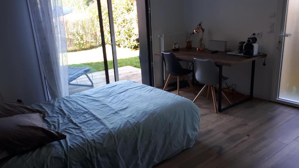 1 dormitorio con cama, escritorio y mesa en Chasseport, en Saint-Saturnin