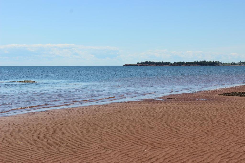 a sandy beach with the ocean in the background at Cottages On PEI in Bedeque