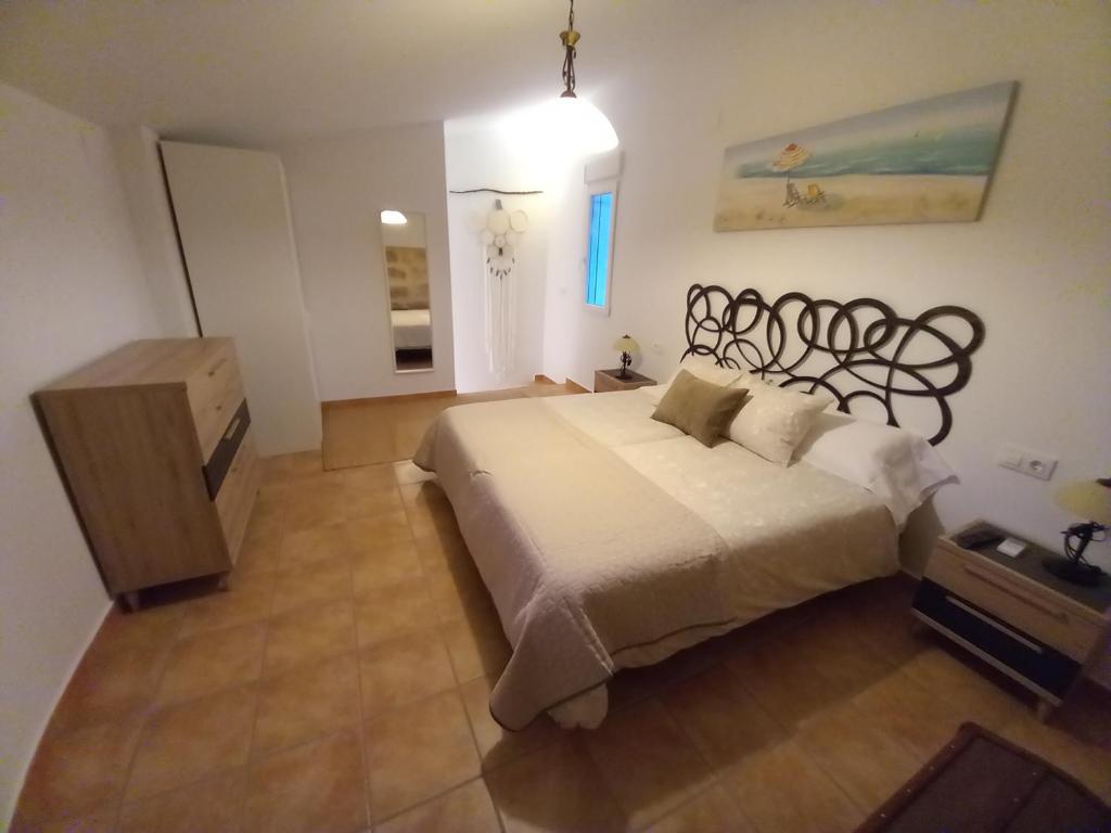 a bedroom with a large bed and a dresser in it at SOBERANA JAVEA in Jávea