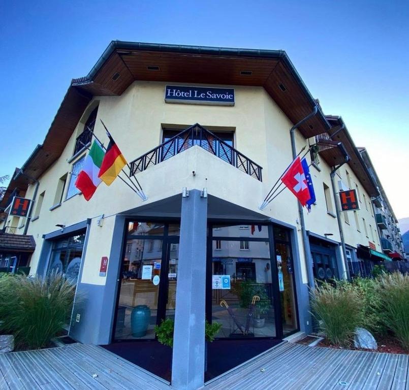 a building with flags in front of it at Hôtel Le Savoie in Albertville