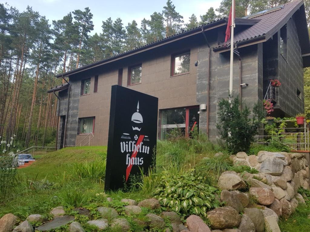 ein Gebäude mit einem Schild davor in der Unterkunft Vilhelmhaus in Dėdeliškės