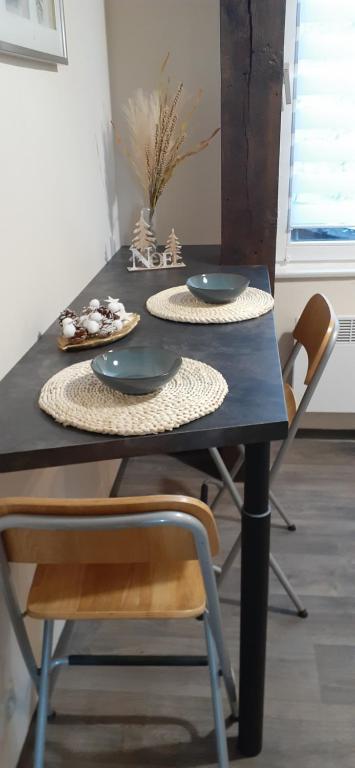 - une table à manger avec deux assiettes et des chaises dans l'établissement Le Rohan, à Colmar