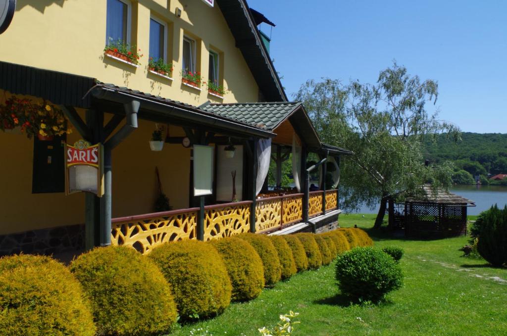 una casa con setos bien recortados delante de ella en Penzión Prameň en Vinné