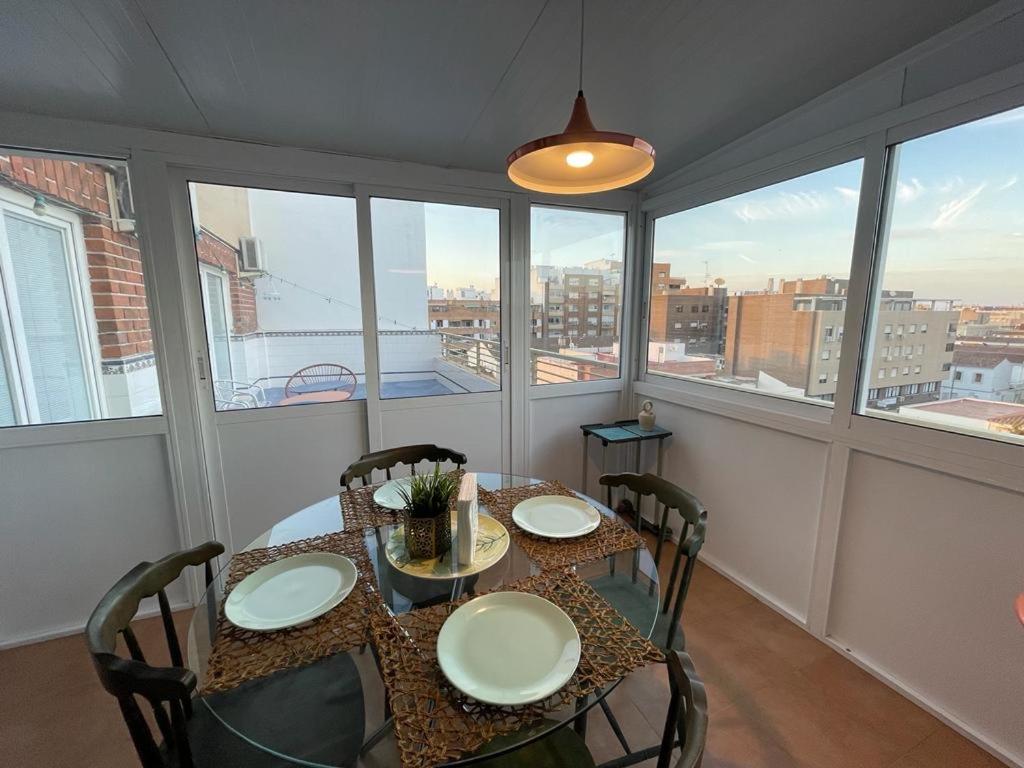 a dining room with a table and chairs and windows at UIM Mediterraneo ATICO San Pedro Wifi in Puerto de Sagunto