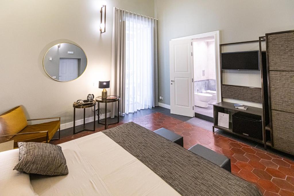a bedroom with a large bed and a mirror at Cuevas Home Relais in Naples
