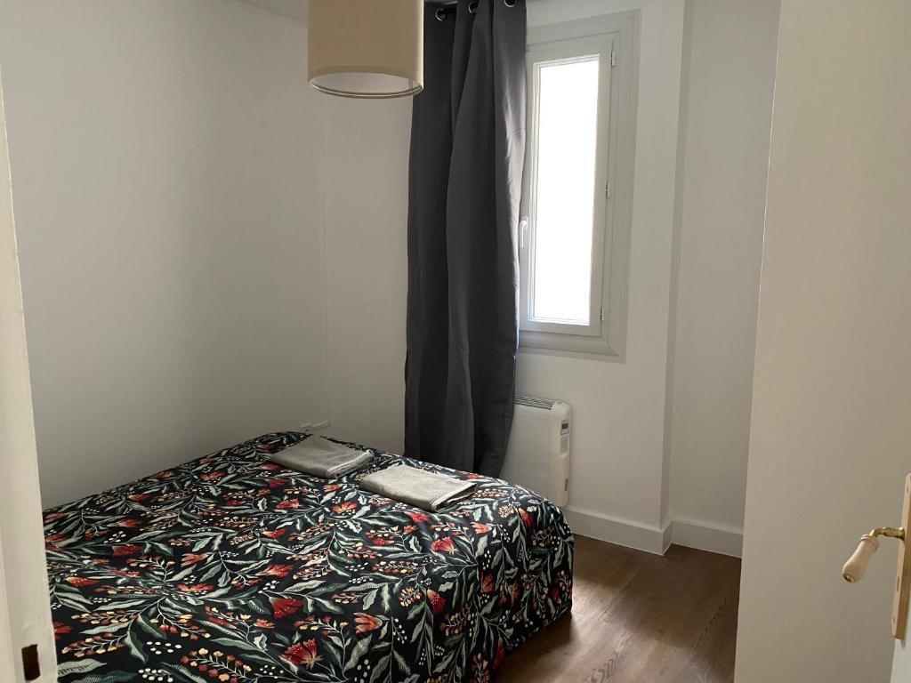 a bedroom with a bed in a room with a window at « Quartier des arts » de vivre à la Toulonnaise in Toulon