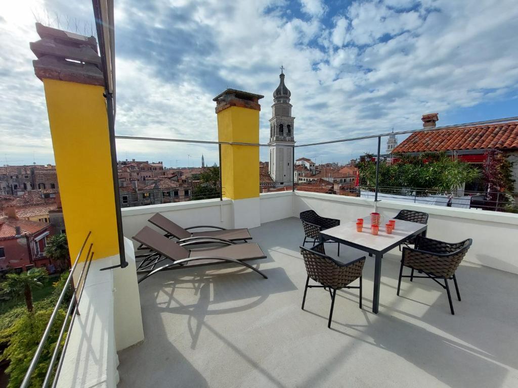 d'un balcon avec des chaises, une table et une tour d'horloge. dans l'établissement Ca' Francesca Suite Terrace in Venice, à Venise