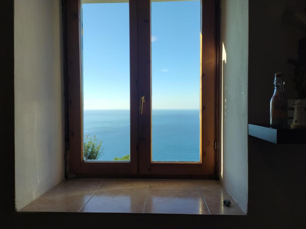 an open door with a view of the ocean at Ostello ninin de ma' in Framura