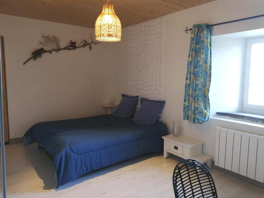 Un dormitorio con una cama azul y una ventana en Chambres et table d'hôtes Régord'âne, en Le Brignon