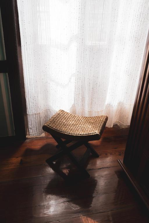 a wicker bench sitting in front of a window at Casa rural El Hornillo in Vallehermoso