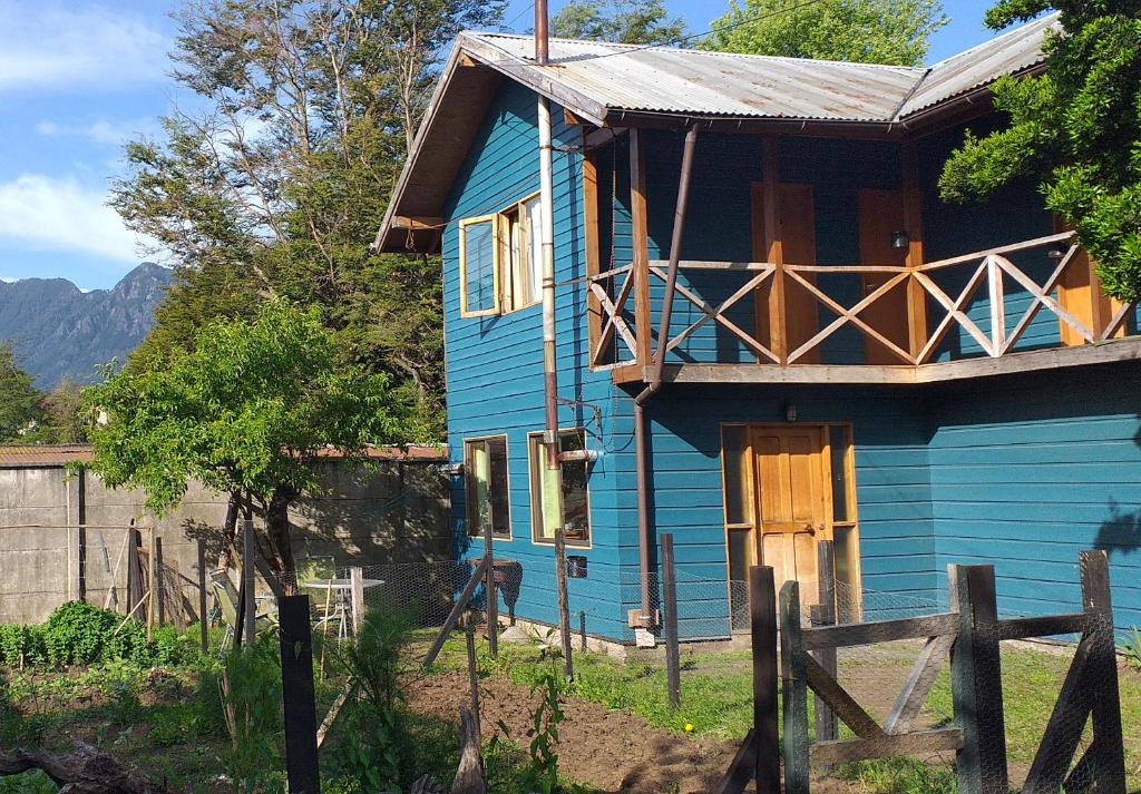 a blue house with a porch on top of it at Hospedaje Picoyo in Pucón