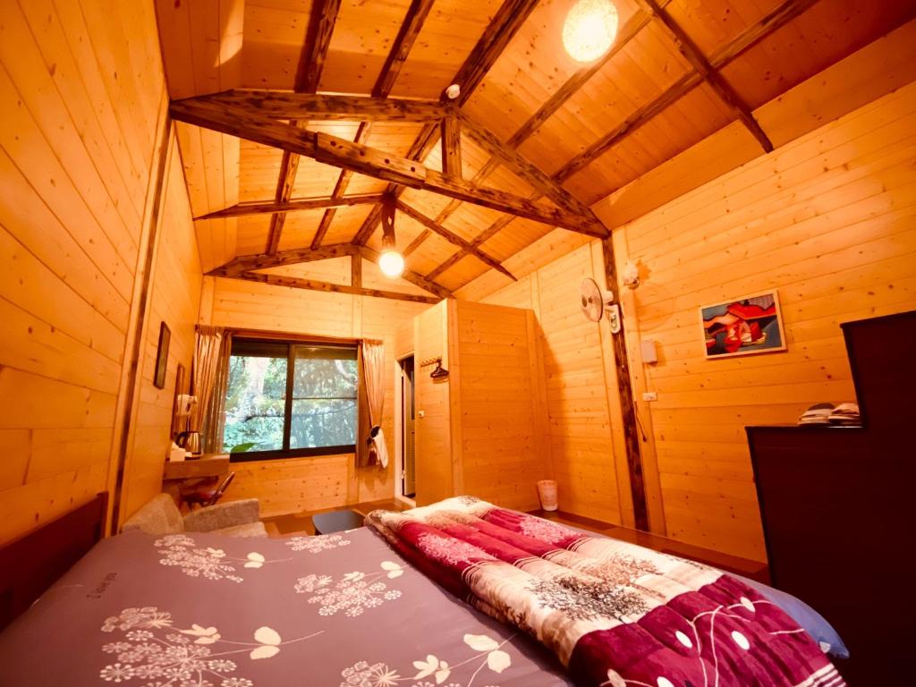 - une chambre avec un lit dans une pièce en bois dans l'établissement Golden Leather Carving Studio, à Leye