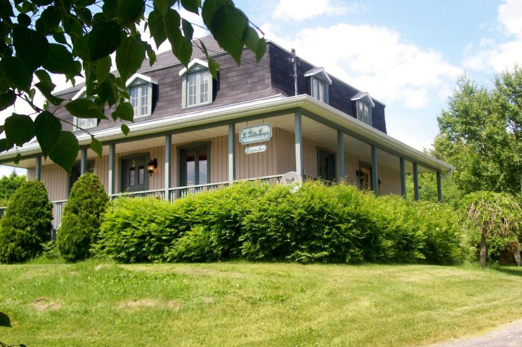 a large house with bushes in front of it at La Belle Époque in La Malbaie