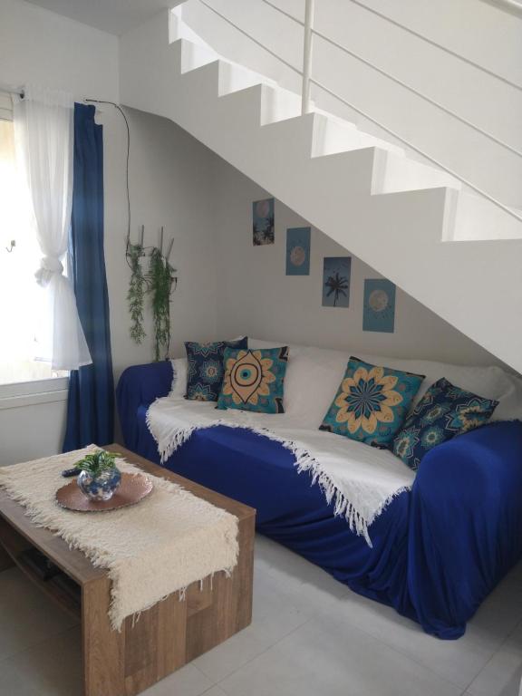 sala de estar con sofá y mesa en Apartamento BLUE 04 - 100 metros da praia en São Lourenço do Sul
