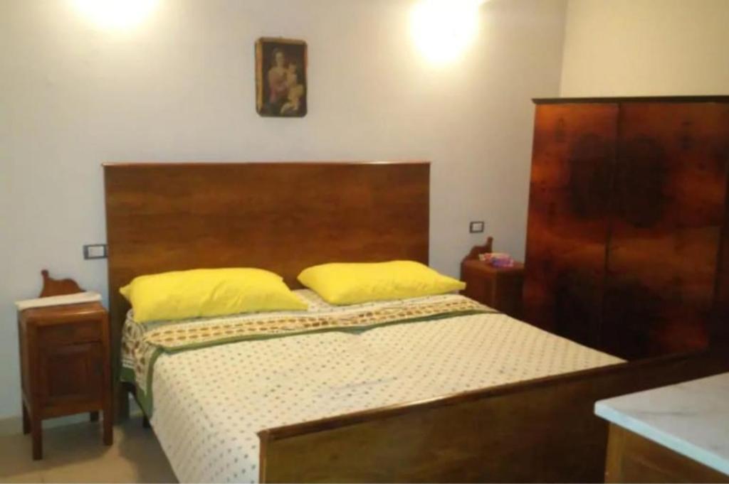 1 dormitorio con 1 cama con almohadas amarillas en Casa indipendente a pochi passi dal mare, en Bova Marina