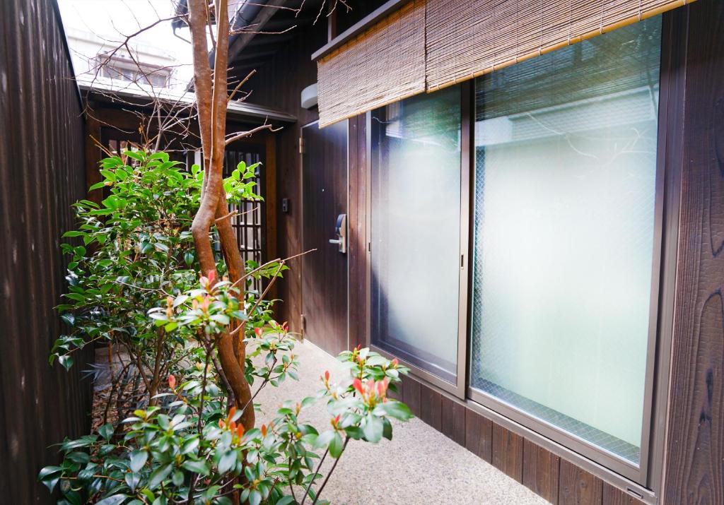 a window on the side of a building with plants at Hotel Zipangu Tameikecho in Kyoto