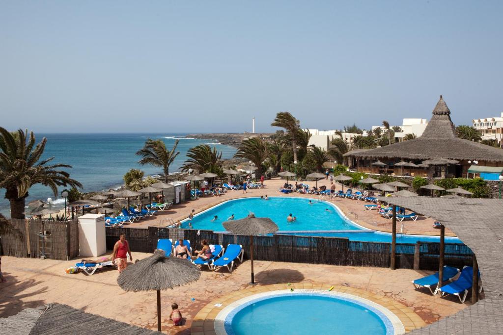 a beach filled with lots of tables and chairs at SBH Hotel Royal Mónica in Playa Blanca