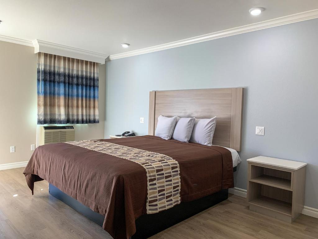 ein Schlafzimmer mit einem großen Bett und einem Fenster in der Unterkunft Mojave Inn in Victorville