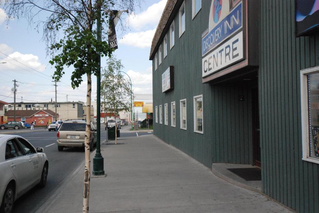 ein grünes Gebäude mit einem Schild an der Straßenseite in der Unterkunft Discovery Inn in Yellowknife