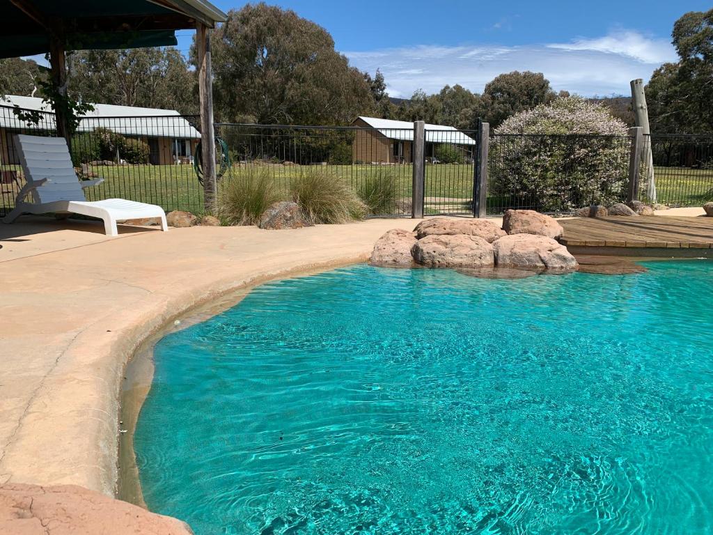 a pool with a pool table and chairs in it at Pomonal Cottages Grampians in Halls Gap
