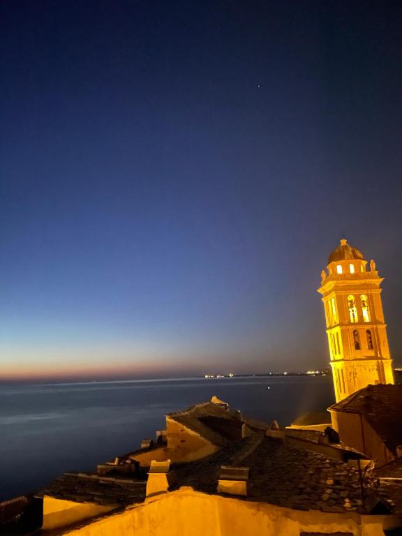 a building with a clock tower in front of the water at CASA GUASCO superbe duplex au cœur de la Citadelle, vue à 360 in Bastia