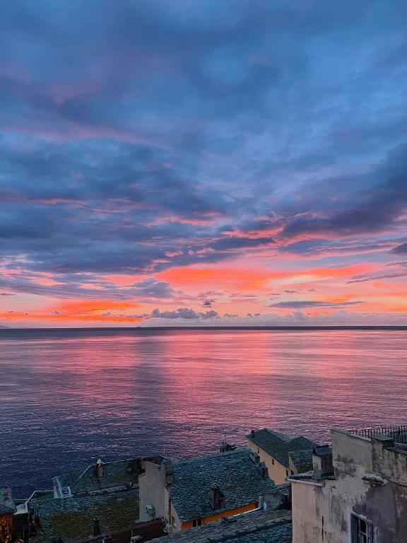 a sunset over a body of water with buildings at CASA GUASCO superbe duplex au cœur de la Citadelle, vue à 360 in Bastia