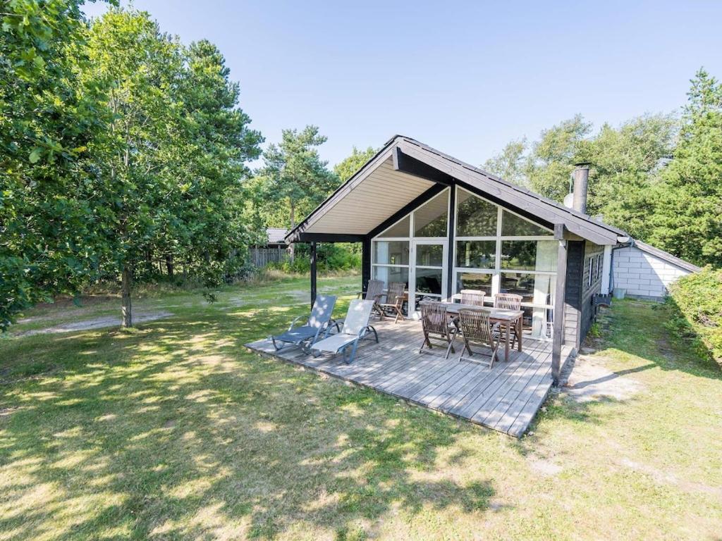 a house with a deck with a table and chairs at 6 person holiday home in Nørre Nebel in Nørre Nebel