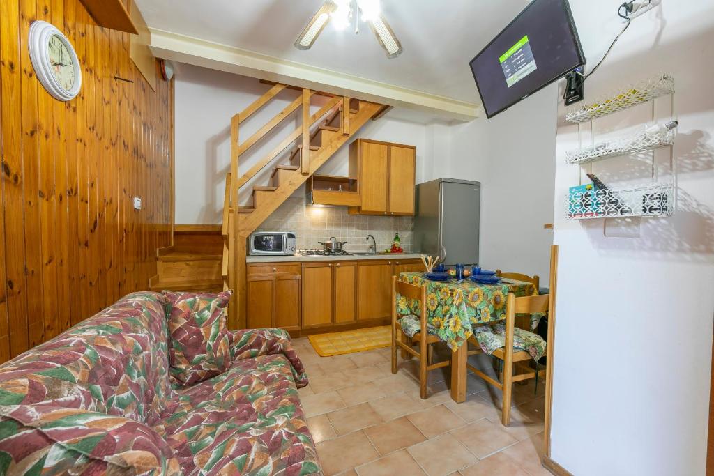 een woonkamer met een bank en een keuken bij Casa di Paolo 50m from beach - Happy Rentals in Letojanni