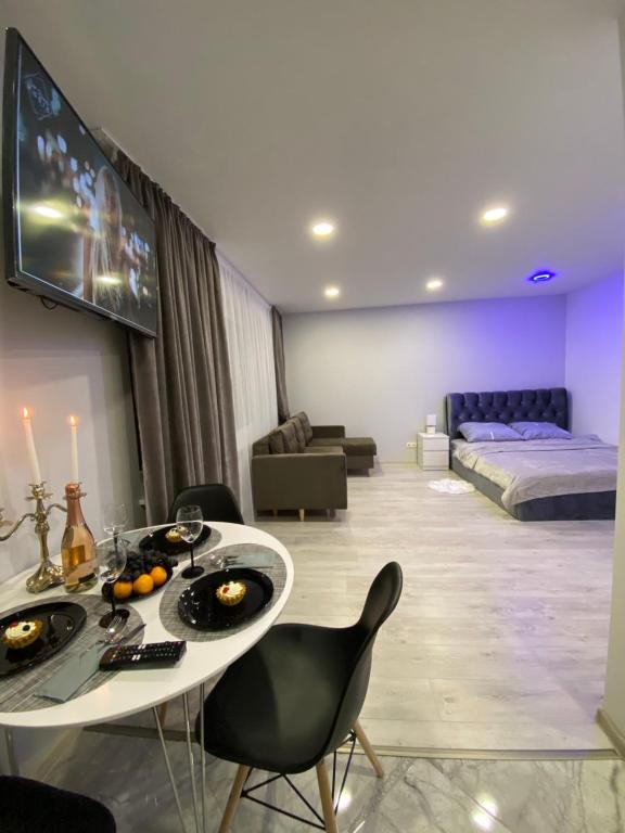 een woonkamer met een tafel en stoelen en een bed bij Crystal Twin Apartment in Gulbene
