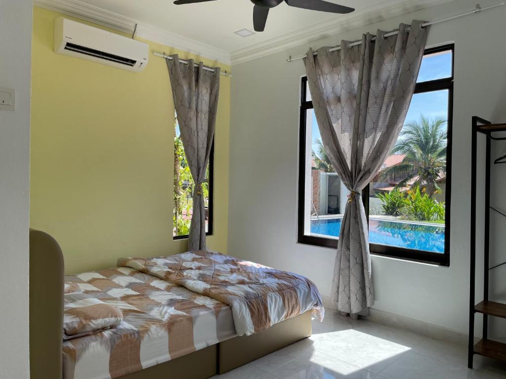 a bedroom with a bed and a window with a pool at Laura Guest House Langkawi in Pantai Cenang