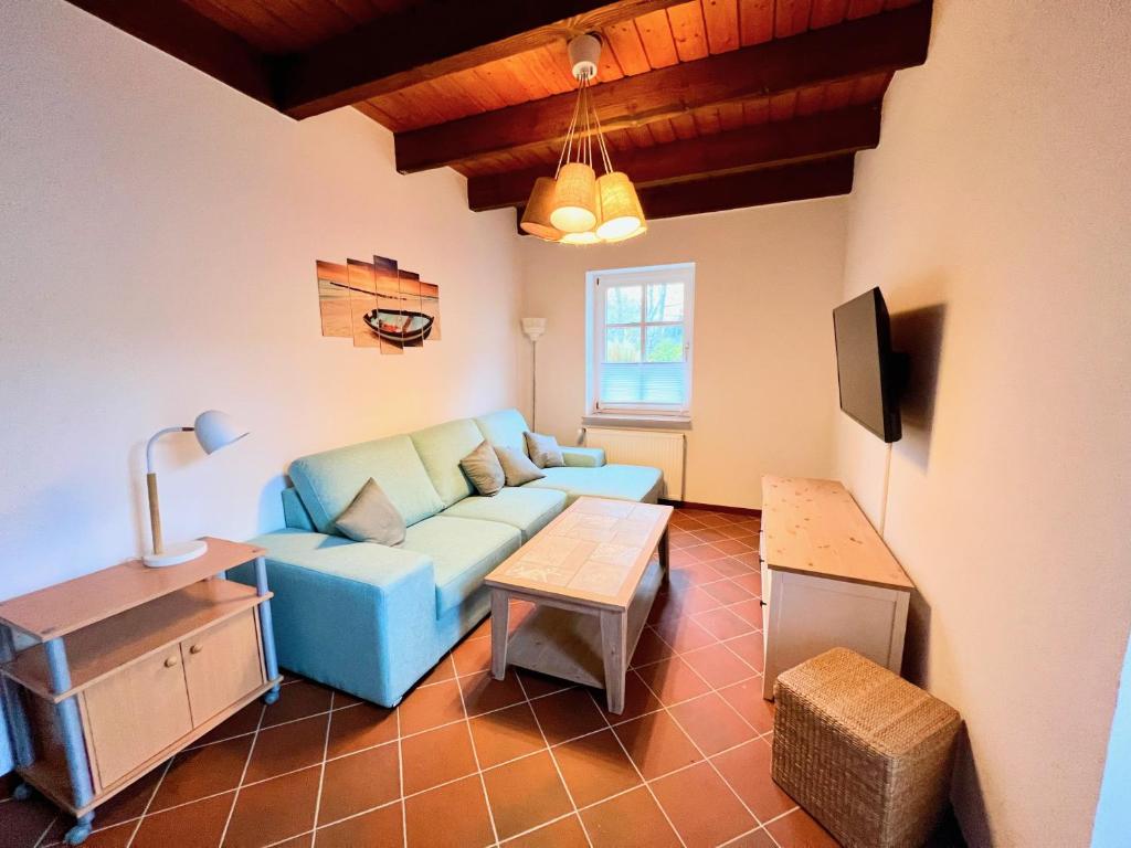 a living room with a blue couch and a table at 2 Zimmer Business Wohnung mit Terrasse in Ahrensburg