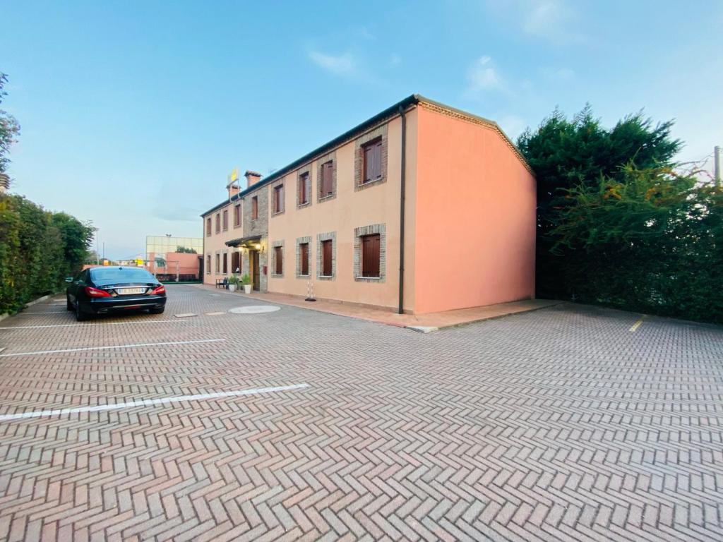 a car parked next to a building on a street at Hotel Le Corti in Ferrara