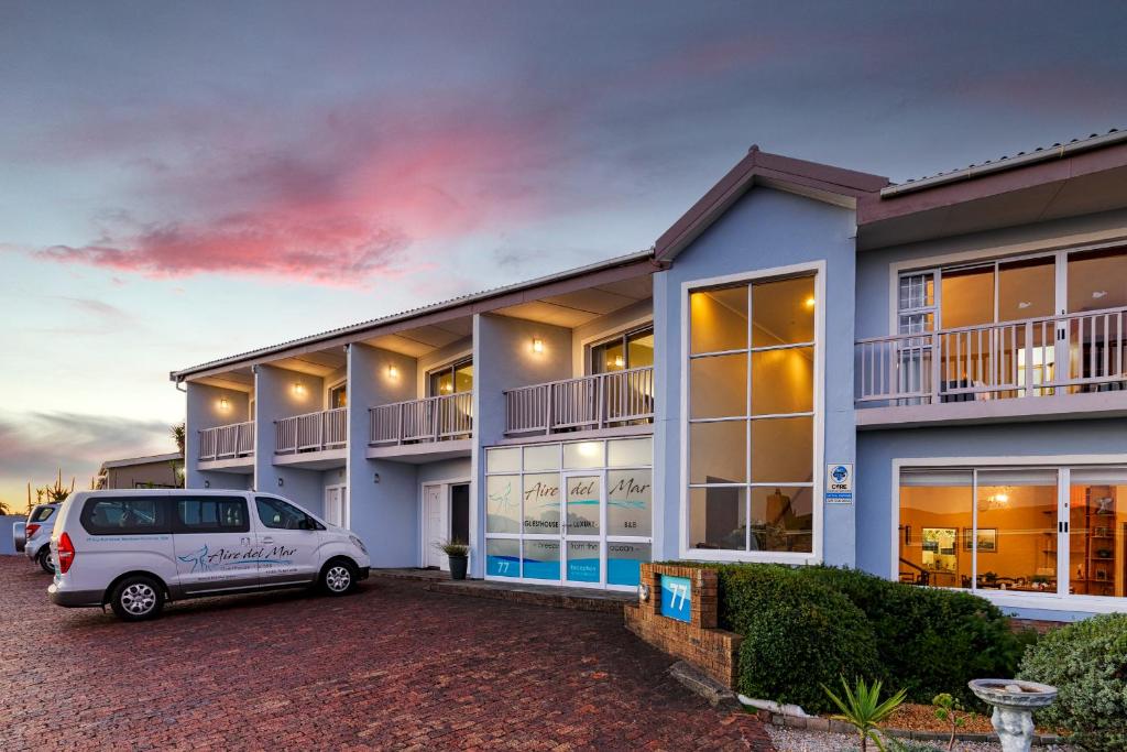 uma carrinha branca estacionada em frente a um edifício em Aire del Mar Guest House em Gansbaai