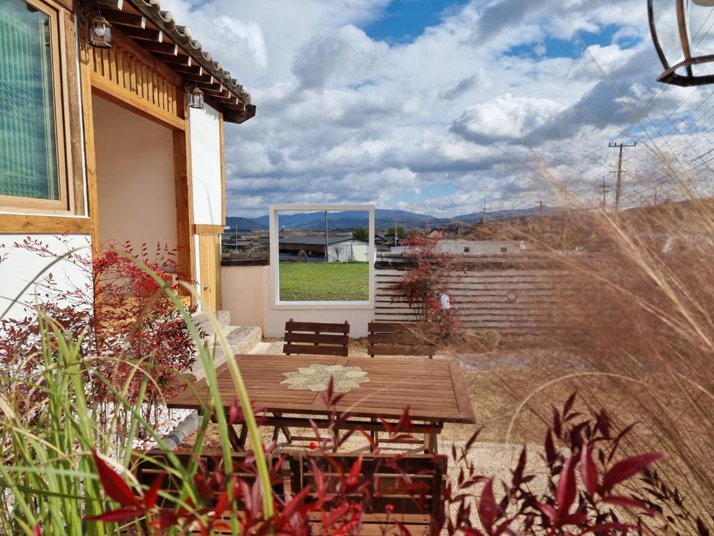 a patio with a wooden table and a window at Stay Gyeongju in Gyeongju