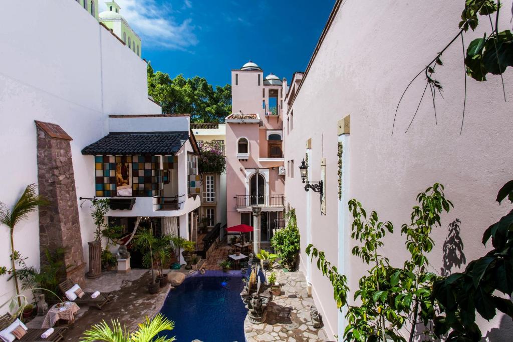 an alleyway between two buildings with a swimming pool at Garlands Del Rio in Puerto Vallarta