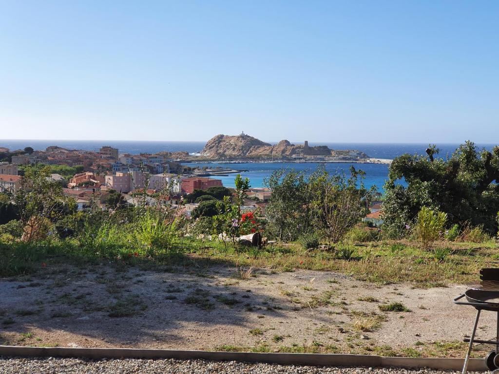 a view of a city and the ocean from a hill at Romane in LʼÎle-Rousse