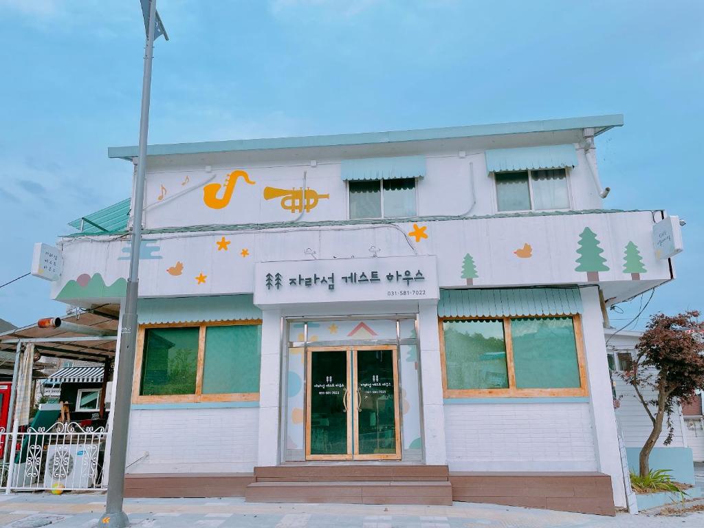 um edifício branco com um cartaz em Jarasum Guest House em Gapyeong