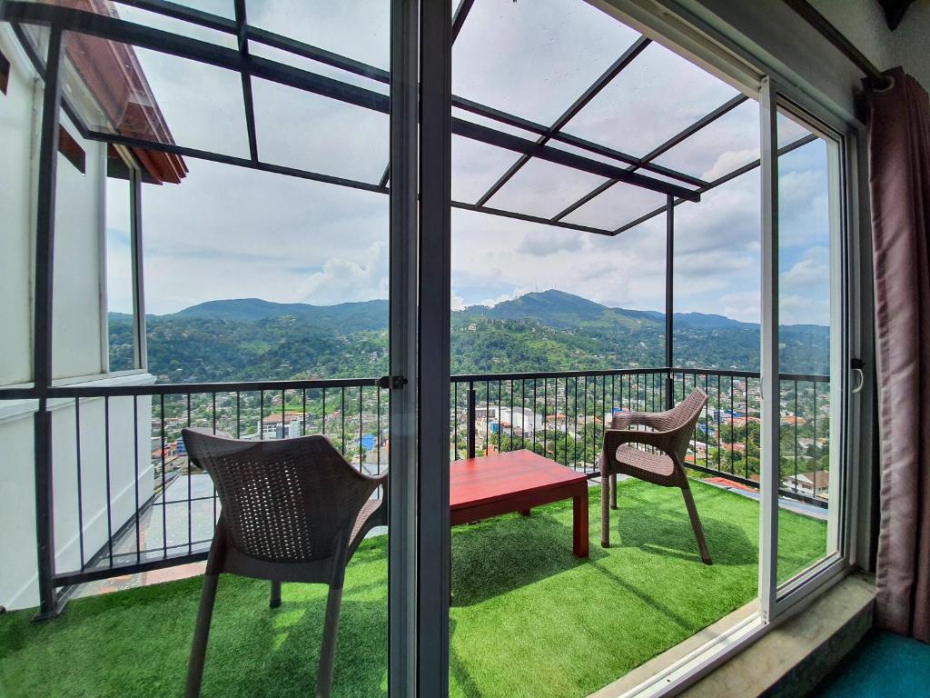 a balcony with a red table and two chairs at The SkyDeck Kandy in Kandy