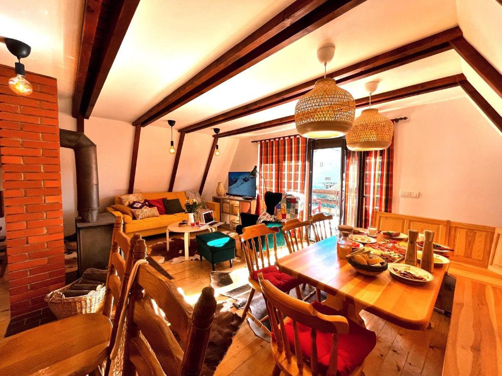 una sala da pranzo e un soggiorno con tavolo in legno di Kuća na Kopaoniku - Rani mraz a Kopaonik
