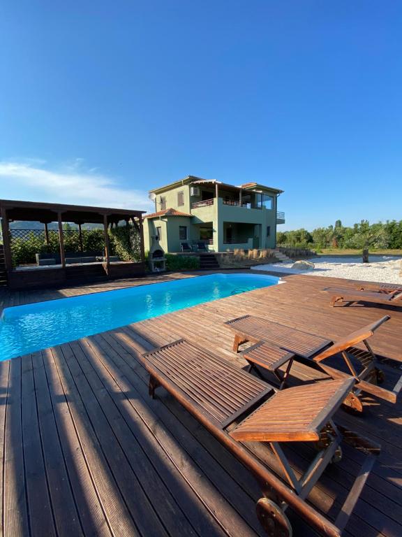 - une piscine sur une terrasse avec des chaises et une maison dans l'établissement Thespis Villa 1, à Sikia