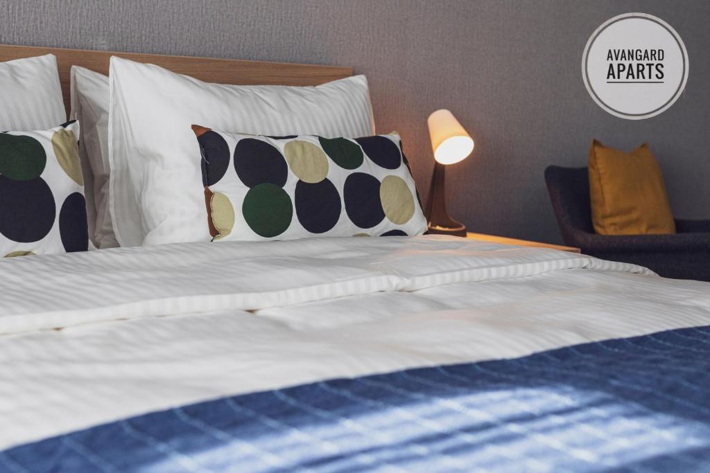 - une chambre avec un lit doté de draps et d'oreillers blancs dans l'établissement Avangard Aparts - Zaman-2, à Atyraū