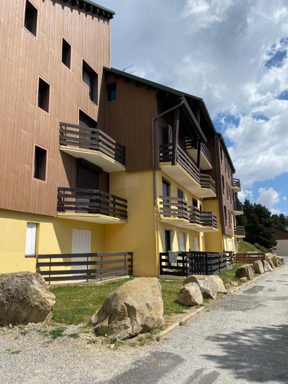 un edificio con rocce di fronte di Les Myrtilles Pyrénées 2000 a Bolquere Pyrenees 2000