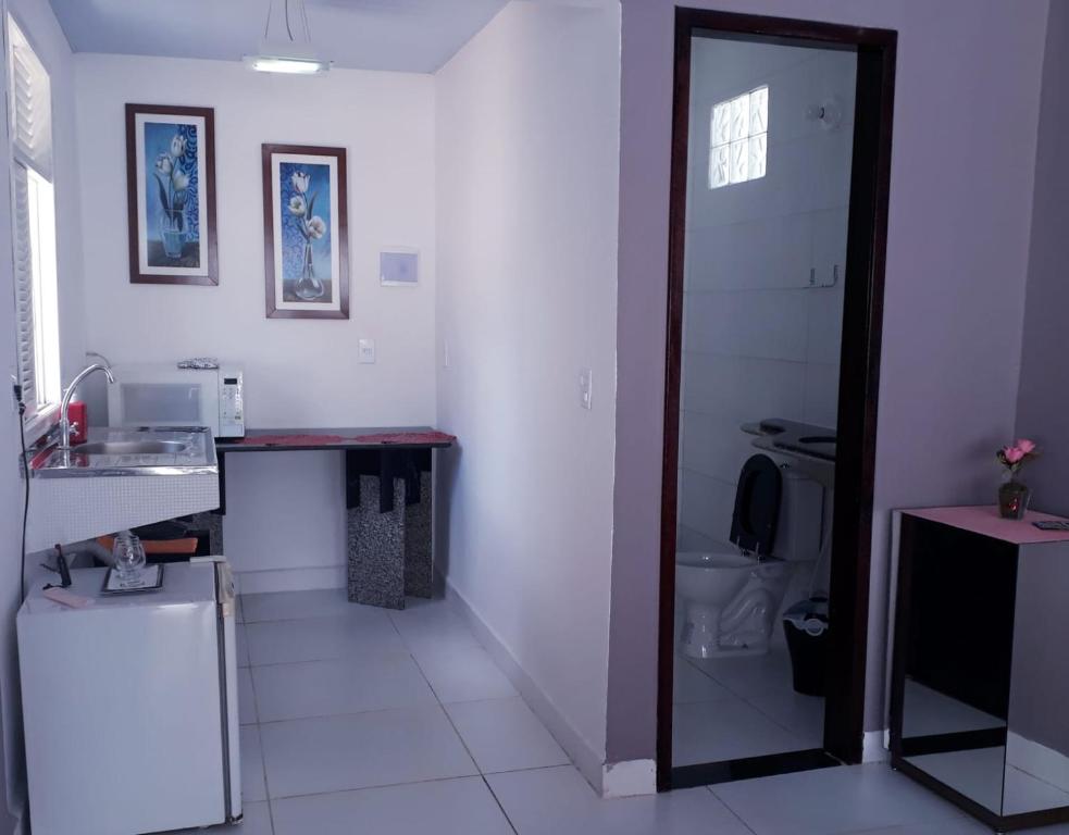a kitchen with a counter and a sink and a refrigerator at Isa Natal 3 Banheiro Privativo in Natal