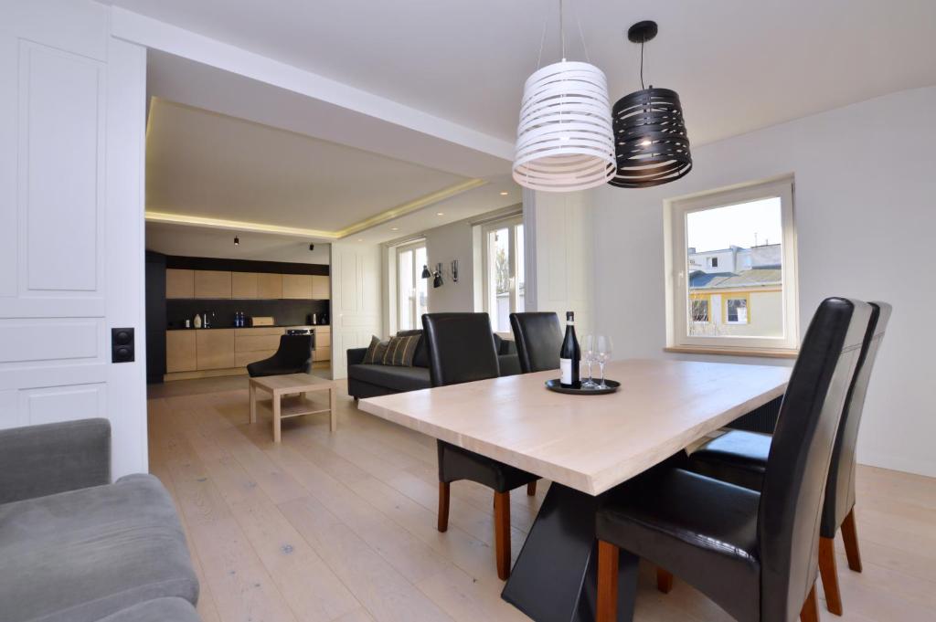 a dining room and living room with a table and chairs at Victus Apartamenty, Apartament Aura in Sopot